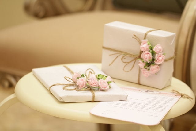 A white gift wrapped with pink roses on a table in San Antonio.