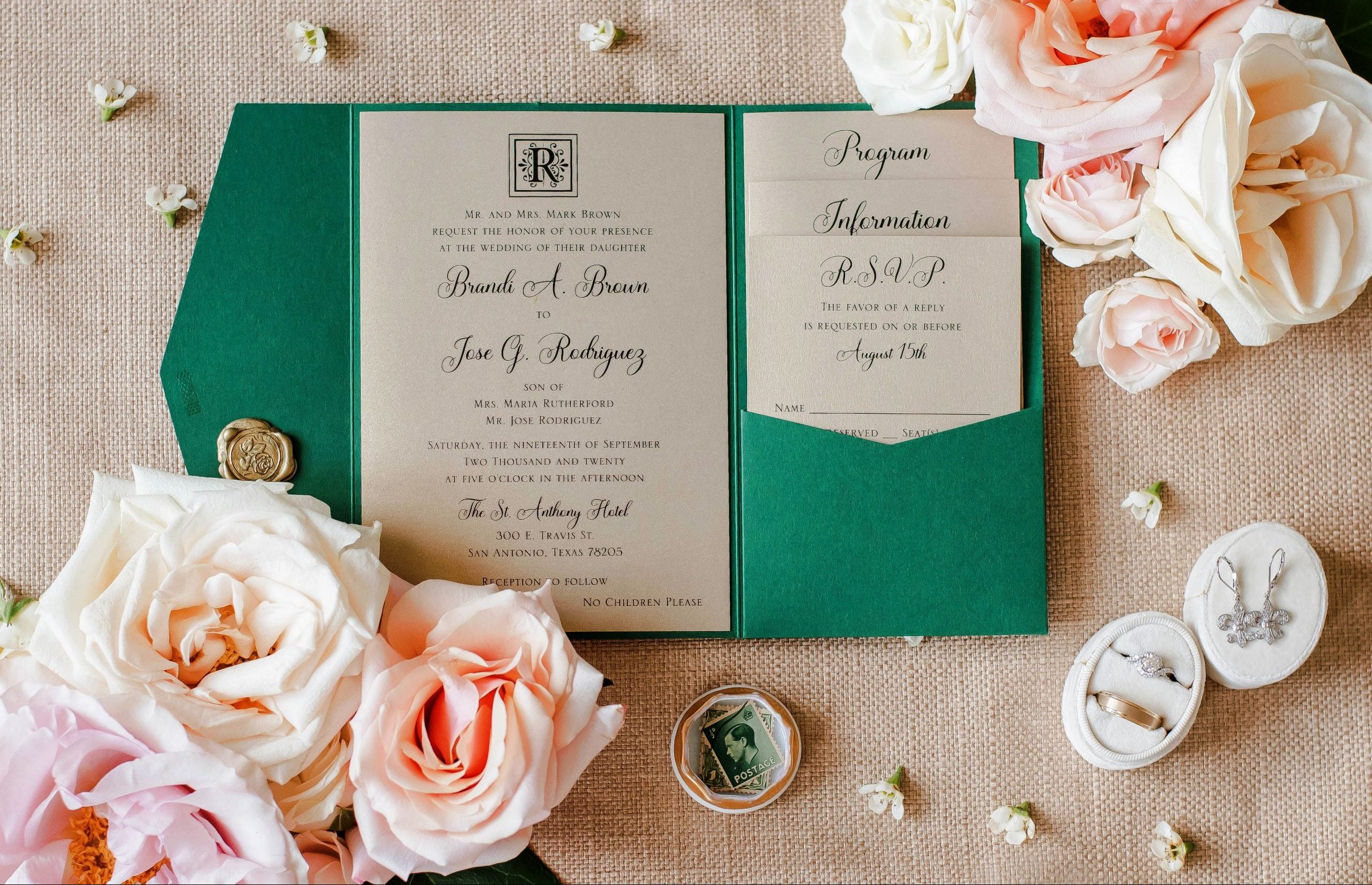 A green wedding invitation adorned with roses, perfect for a luxurious San Antonio wedding.